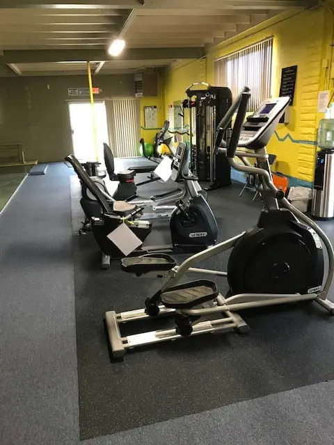 The fitness center with recumbent bikes, an elliptical, and a cable machine